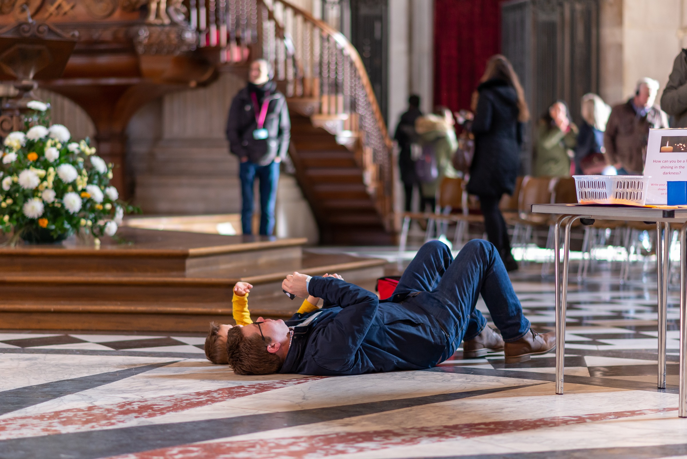 father and child lying down looking up at the Dome ceilling