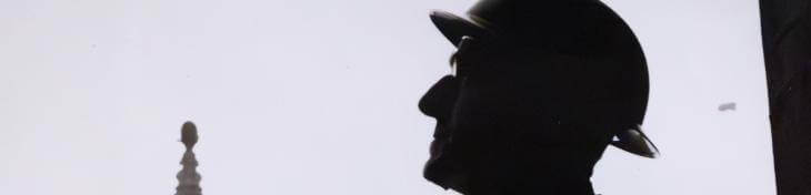 a silhouette of a male figure wearing a hat against a background of St Paul's bell tower