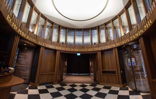 The wooden elliptical interior of the Remember Me inner portico is shown reading 'Remembering all who died as a result of the coronavirus pandemic'