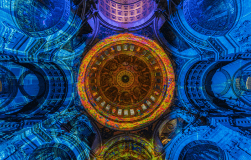 The dome of St Paul's lit with an orange pattern, surrounded by blue walls.
