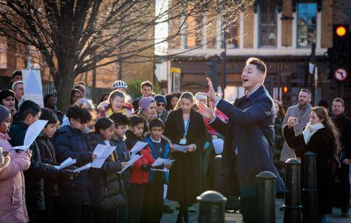 Conductor leading school choir outdoors