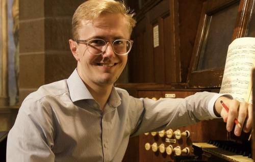 Hamish Wagstaff sits at an organ manual.